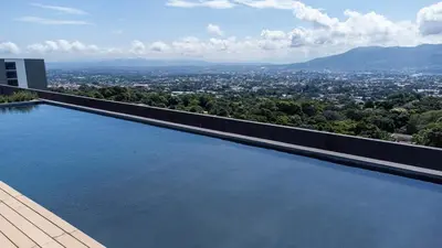 a swimming pool on top of a building with a city at Exclusive Apartment with Pool & Rooftop in El Salvador in San Salvador