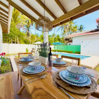 a wooden table with plates and a bottle of wine at Bungalow en La Playa- Amatecampo Villas in La Esmeralda