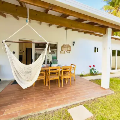 a hammock on a patio with a table and chairs at Bungalow en La Playa- Amatecampo Villas in La Esmeralda