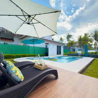 a villa with a swimming pool and an umbrella at Bungalow en La Playa- Amatecampo Villas in La Esmeralda