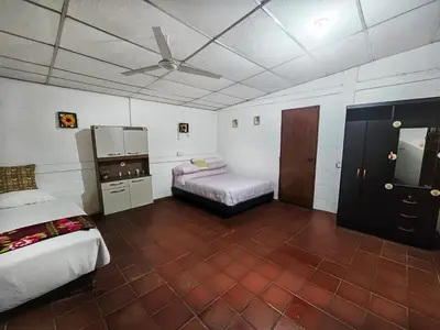 a bedroom with two beds and a ceiling fan at Rancho Samba do Sol in Acajutla