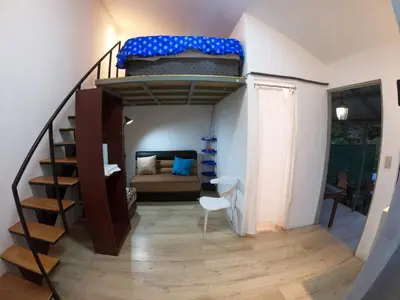 a room with a staircase leading to a bedroom at Mini casa de árbol, mágica, céntrica y de vistas panorámicas in San Salvador