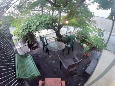 a patio with a table and chairs and a tree at Mini casa de árbol, mágica, céntrica y de vistas panorámicas in San Salvador