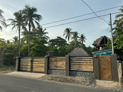 a wooden fence next to a road with palm trees at Container house in La Esmeralda