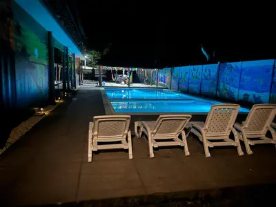 a group of chairs next to a swimming pool at night at Container house in La Esmeralda