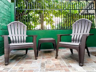 two chairs and a table in front of a green wall at Casa Independencia de Santa Ana in Santa Ana