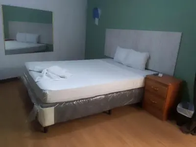 a bed in a room with a mirror and a bed sidx sidx sidx at Casa de Huéspedes Noche de Luna in San Salvador