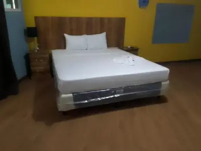 a bedroom with a white bed with a wooden headboard at Casa de Huéspedes Noche de Luna in San Salvador
