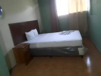 a bed in a small room with a white mattress at Casa de Huéspedes Noche de Luna in San Salvador
