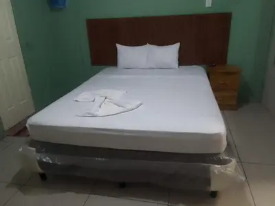 a bed with two white towels on top of it at Casa de Huéspedes Noche de Luna in San Salvador