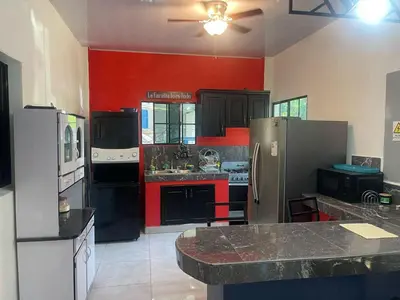 a large kitchen with black appliances and red walls at Evolution Home in Astoria