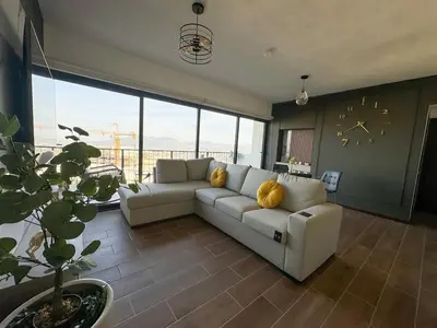 a living room with a couch and a clock on the wall at View of The Capital, Escalon SV in San Salvador