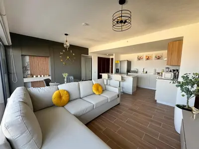 a living room with a white couch and a kitchen at View of The Capital, Escalon SV in San Salvador