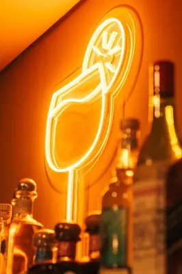 a neon sign that is on a wall with bottles at Spacious Apartment with Balcony in El Zonte