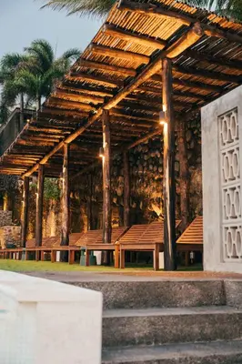 a pavilion with benches and palm trees and a building at Spacious Apartment with Balcony in El Zonte