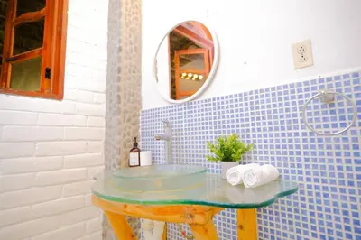 a bathroom with a glass sink and a mirror at Casa K59 - Walk to Beach in Taquillo