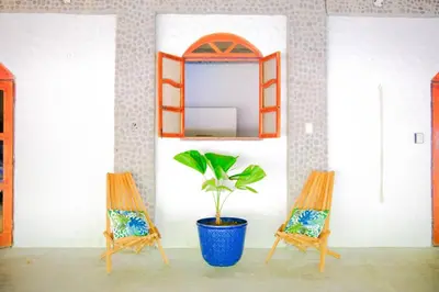 two chairs and a plant in a room with a mirror at Casa K59 - Walk to Beach in Taquillo