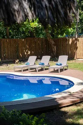 two lounge chairs sitting next to a swimming pool at Casa K59 - Walk to Beach in Taquillo