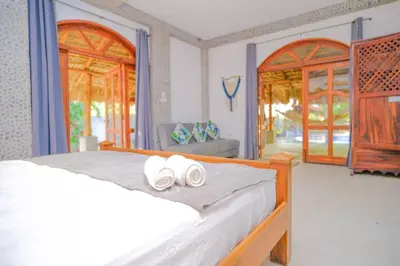 a bedroom with a bed with two rolled towels on it at Casa K59 - Walk to Beach in Taquillo
