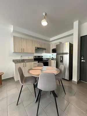a kitchen with a table and chairs and a refrigerator at Apartamento Casas del Árbol Condado Santa Rosa Santa Tecla in Nanastepeque