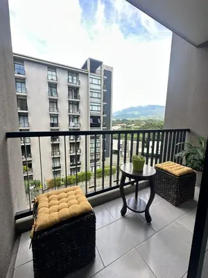 a balcony with a table and a view of a building at Apartamento Casas del Árbol Condado Santa Rosa Santa Tecla in Nanastepeque