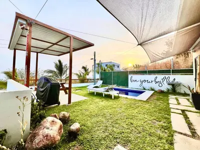 a backyard with an umbrella and a swimming pool at Luxury Apartment- View- Pool- La Libertad Surfcity in La Libertad