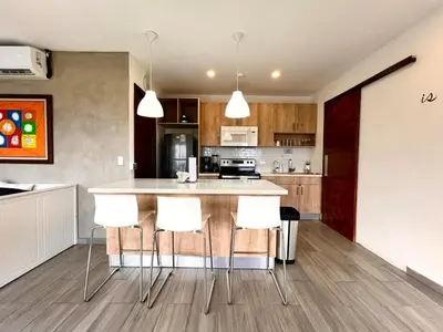 a kitchen with a island with white bar stools at Luxury Apartment- View- Pool- La Libertad Surfcity in La Libertad