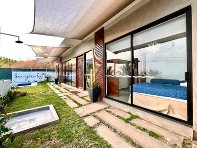 a house with large glass windows and a blue couch at Luxury Apartment- View- Pool- La Libertad Surfcity in La Libertad