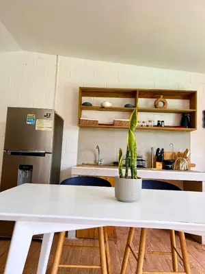 a kitchen with a white table with a plant on it at El Tunco Beachfront Surf City Spot in Tamanique
