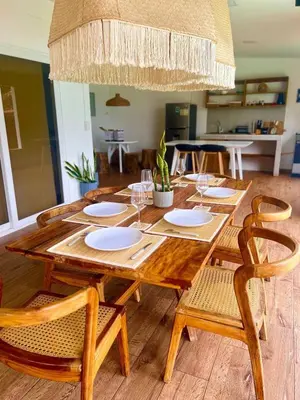 a wooden table with plates and glasses on it at El Tunco Beachfront Surf City Spot in Tamanique
