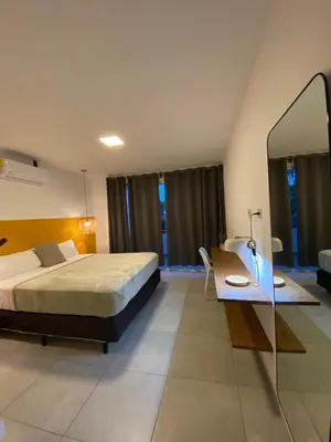 a bedroom with a bed and a desk and a mirror at via costera 1 in La Libertad
