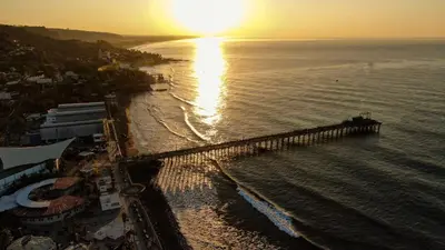 an aerial view of a pier on the beach at sunset at via costera 1 in La Libertad