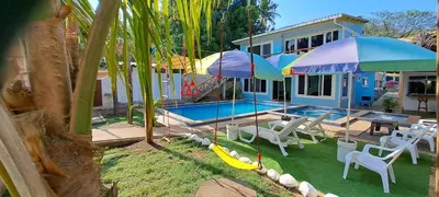 a house with a swimming pool with chairs and umbrellas at California Beach, Teotepeque, La Libertad in Las Victorias