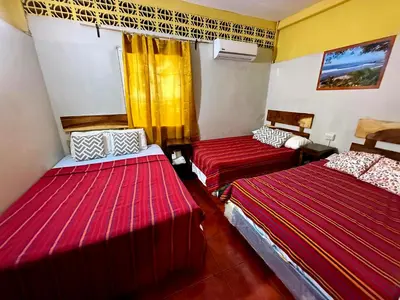 two beds in a room with red sheets at Hotel Casa Miramar in Tamanique