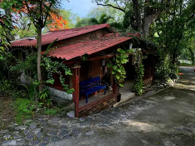 a small house with a blue bench in front of it at Hotel Casa Miramar in Tamanique