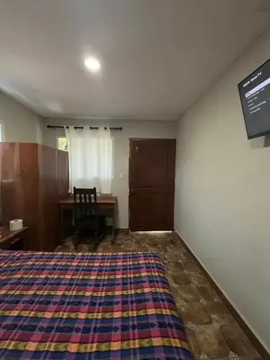 a bedroom with a bed and a desk and a table at Hotel Casa Miramar in Tamanique