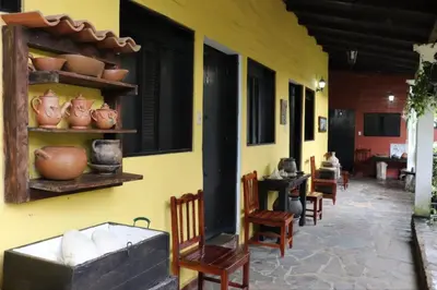 a room with chairs and vases on a yellow wall at Hotel Villa Santo Domingo in Concepción de Ataco