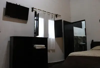 a bedroom with a bed and a dresser with a television at Hotel Villa Santo Domingo in Concepción de Ataco