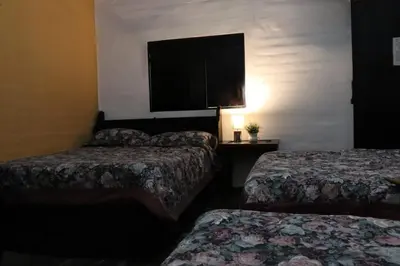 a hotel room with two beds and a flat screen tv at Hotel Villa Santo Domingo in Concepción de Ataco
