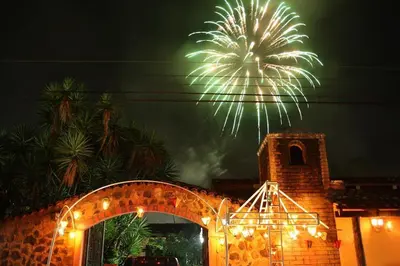 a fireworks display over a building with a tower at Hotel Villa Santo Domingo in Concepción de Ataco