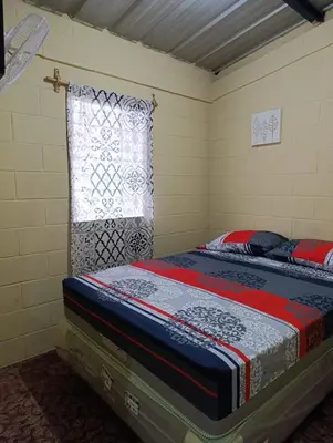 a bed in a room with a window at Room Buganvilia in Nahuizalco