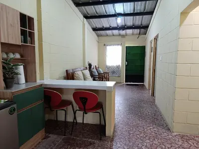 a kitchen with red chairs and a counter in a room at Room Buganvilia in Nahuizalco