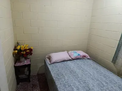 a small room with a bed and a vase of flowers at Room Buganvilia in Nahuizalco