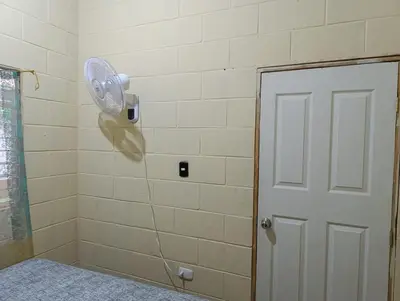 a bathroom with a shower with a fan on the wall at Room Buganvilia in Nahuizalco