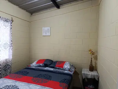 a small bedroom with a bed and a window at Room Buganvilia in Nahuizalco