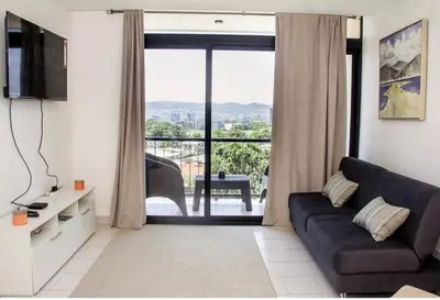 a living room with a couch and a large window at The Balcony of the City in San Salvador