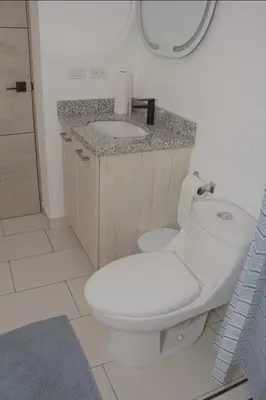 a bathroom with a white toilet and a sink at The Balcony of the City in San Salvador
