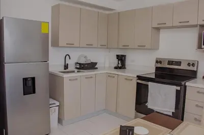 a kitchen with white cabinets and a stove top oven at The Balcony of the City in San Salvador