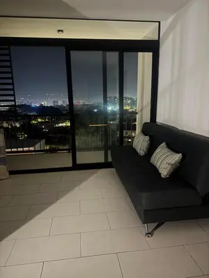 a living room with a couch in front of a window at The Balcony of the City in San Salvador