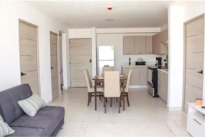 a kitchen and dining room with a table and a couch at The Balcony of the City in San Salvador
